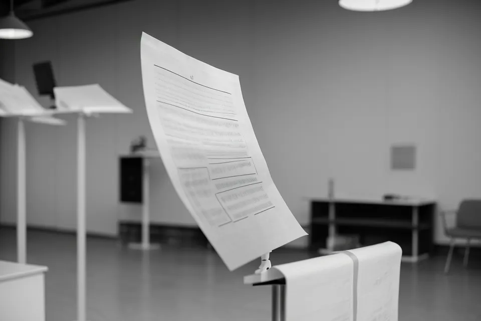Notes de présentation posées sur un pupitre avec un public flou en arrière-plan.